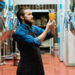 Man håller i ölglas på bryggeri